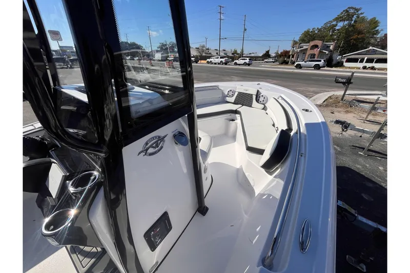 Slide: The Image of 2026 Tidewater 210 LXF boat interior with seating and console, parked on a street. - 7