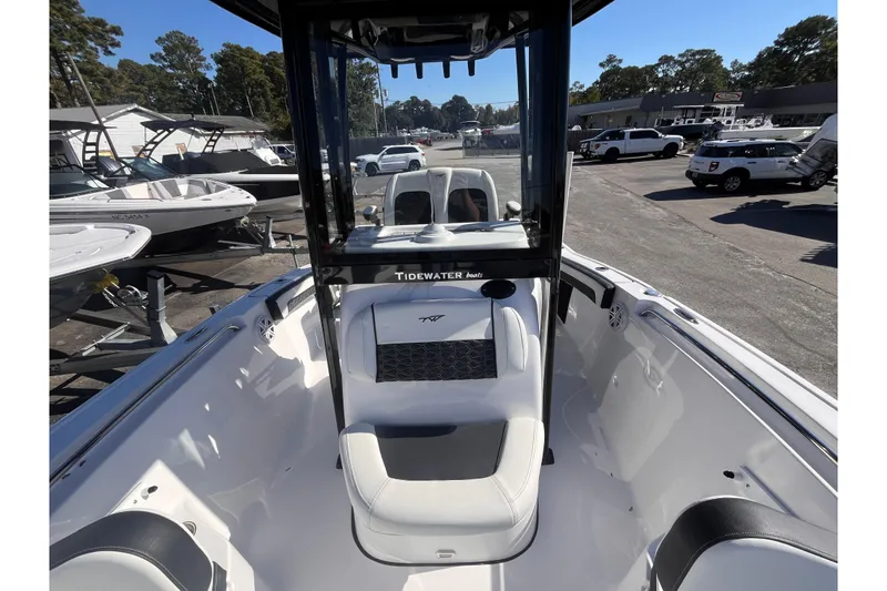 Slide: The Image of 2026 Tidewater 210 LXF boat interior with seating, parked in a marina. - 9