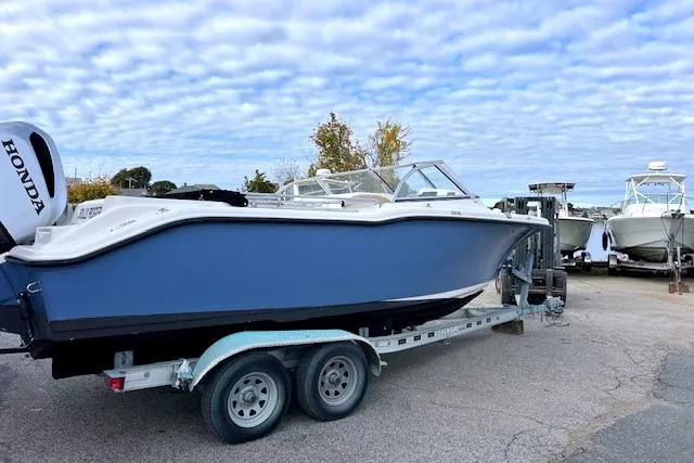 The Image of 2020 Key West 239 DFS boat on trailer with Honda outboard motor, under cloudy sky. - 0