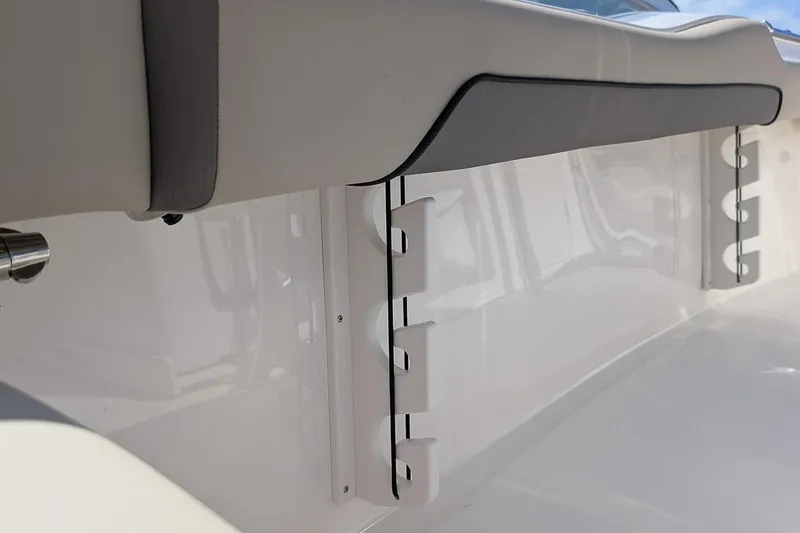 Slide: The Image of 2026 Key West 219 FS boat interior detail with rod holders and cushioned seating. - 10