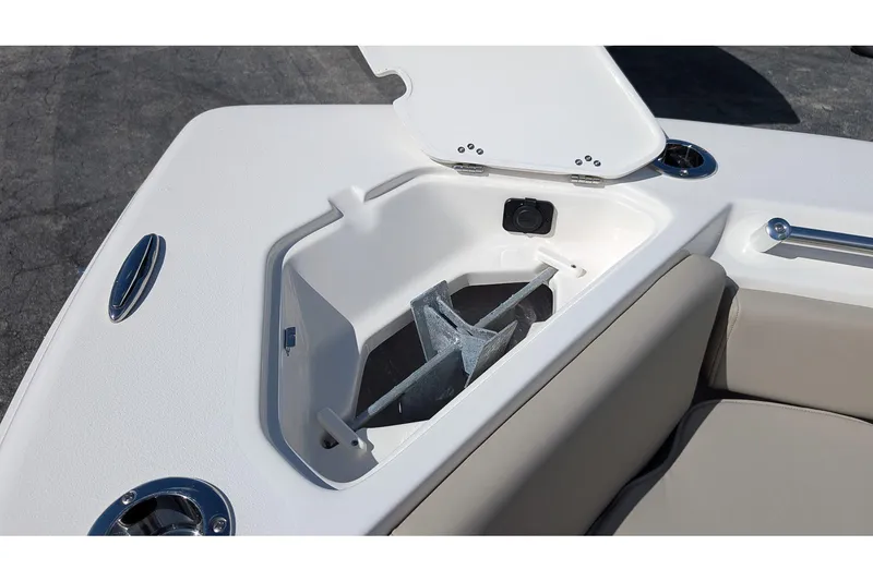 Slide: The Image of 2026 Key West 219 FS boat anchor compartment with open lid and seating area. - 18