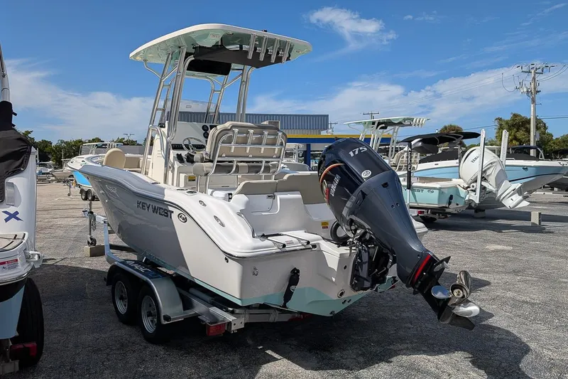 Slide: The Image of 2026 Key West 219 FS boat on trailer, featuring a powerful 175 outboard motor. - 2