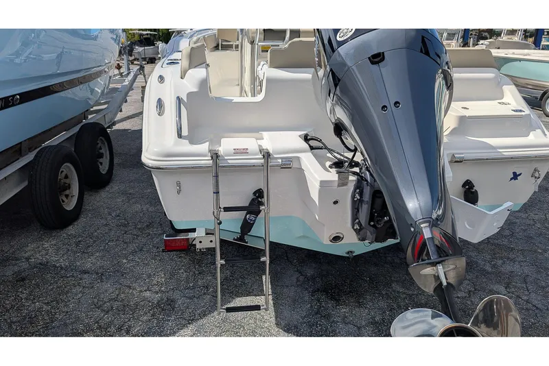 Slide: The Image of 2026 Key West 219 FS boat with outboard motor and ladder, parked on a trailer. - 6