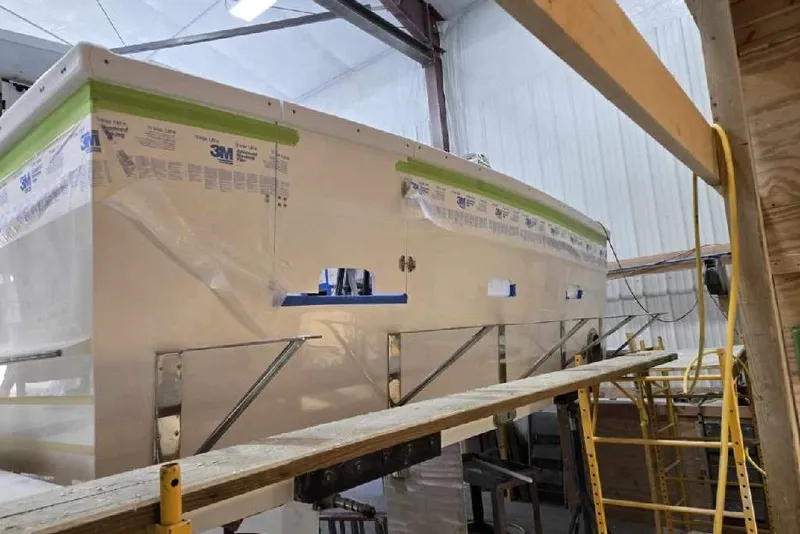 Slide: The Image of 2025 Calvin Beal Sedan boat under construction in a workshop. - 20
