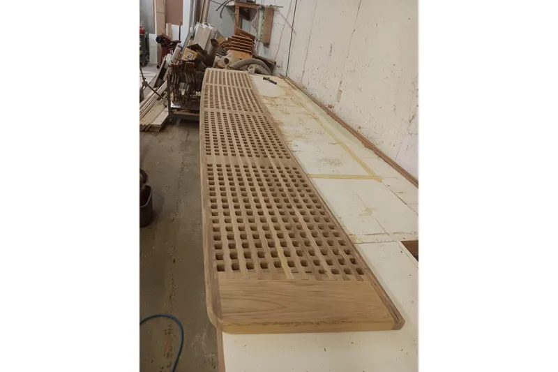 Slide: The Image of Wooden panel with grid pattern in a workshop, possibly for a 2025 Calvin Beal Sedan. - 21