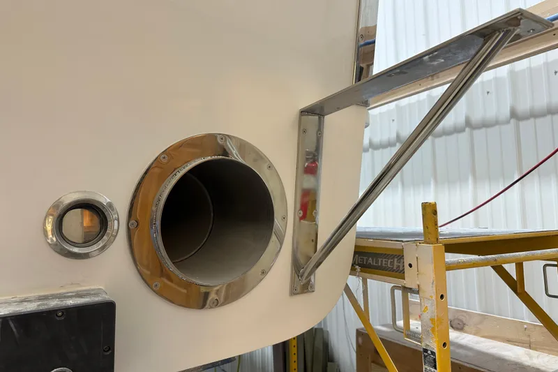Slide: The Image of Calvin Beal 2025 Sedan boat exhaust and porthole in a workshop setting. - 22