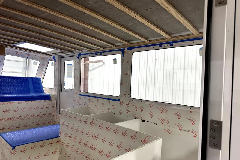 Slide: The Image of Interior of a 2025 Calvin Beal Sedan boat under construction, featuring blue seating. - 26