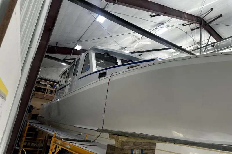 Slide: The Image of 2025 Calvin Beal Sedan boat in a workshop, under construction. - 3