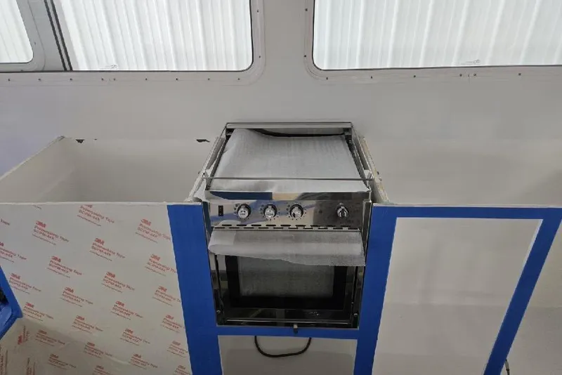 Slide: The Image of Modern kitchen setup inside a 2025 Calvin Beal Sedan, featuring a sleek stainless steel oven. - 35