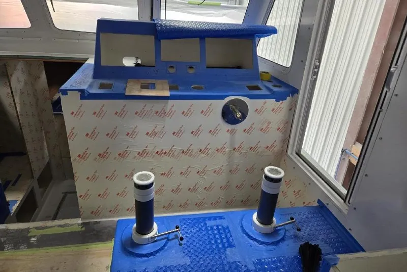 Slide: The Image of Interior of a 2025 Calvin Beal Sedan boat under construction, featuring blue protective coverings. - 36