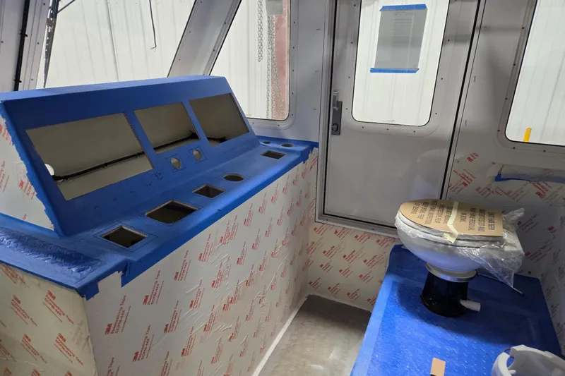 Slide: The Image of Interior of a 2025 Calvin Beal Sedan under construction, featuring a control panel and toilet. - 37