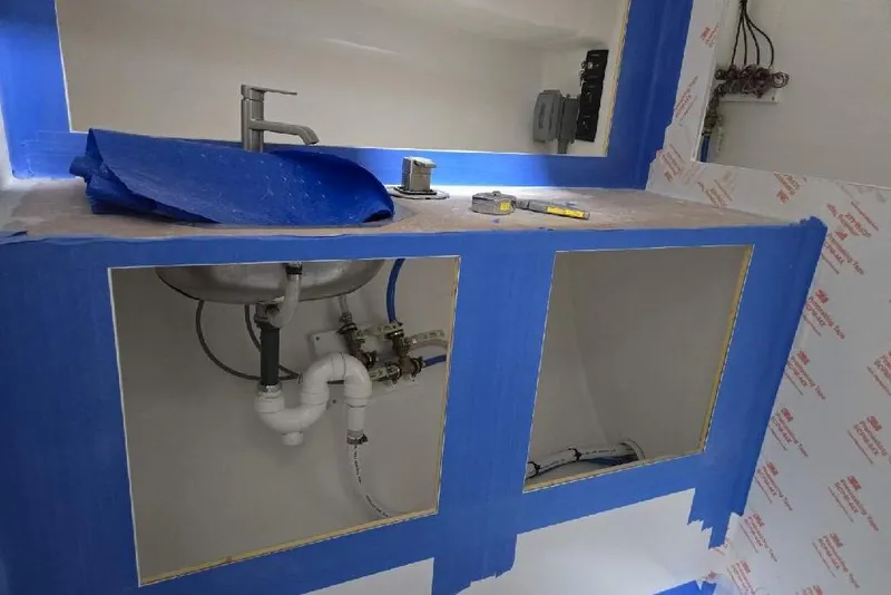 Slide: The Image of Under-sink plumbing installation with blue tape and tools, Calvin Beal Sedan 2025. - 38