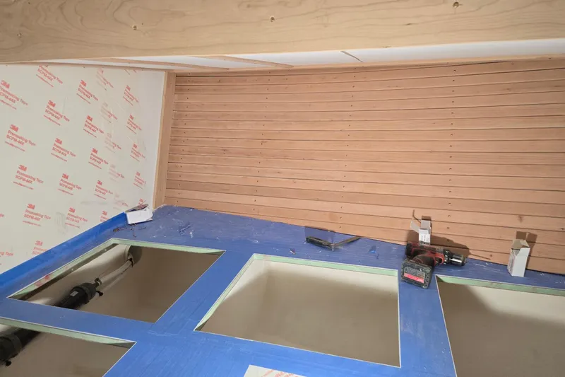 Slide: The Image of Interior construction of 2025 Calvin Beal Sedan, featuring wooden paneling and tool setup. - 41