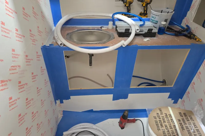 Slide: The Image of Interior of a 2025 Calvin Beal Sedan under construction, featuring tools and plumbing setup. - 44