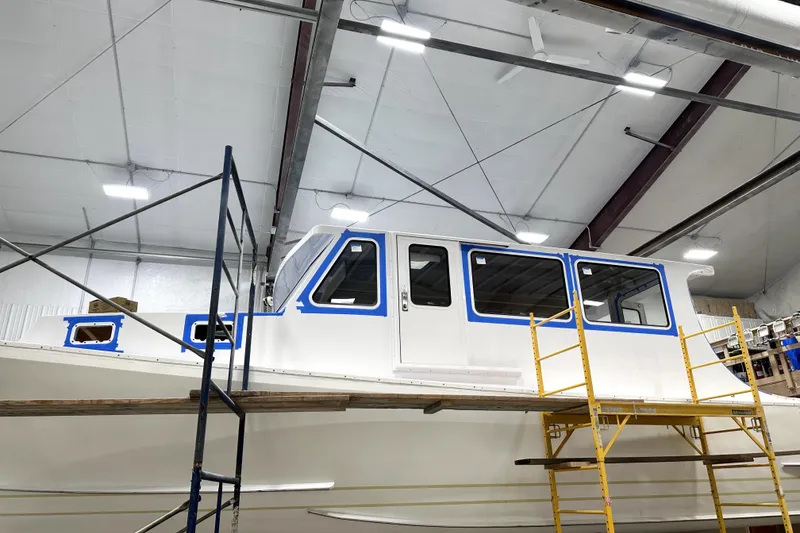 Slide: The Image of A 2025 Calvin Beal Sedan boat under construction in a workshop. - 5