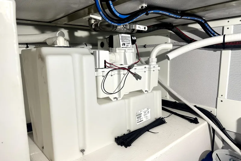 Slide: The Image of 2025 Calvin Beal Sedan engine compartment with wiring and fluid reservoir. - 51