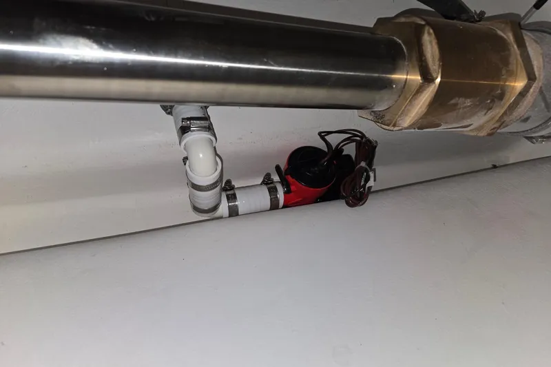 Slide: The Image of Plumbing system with pipes and fittings beneath a surface, featuring a red device. - 55