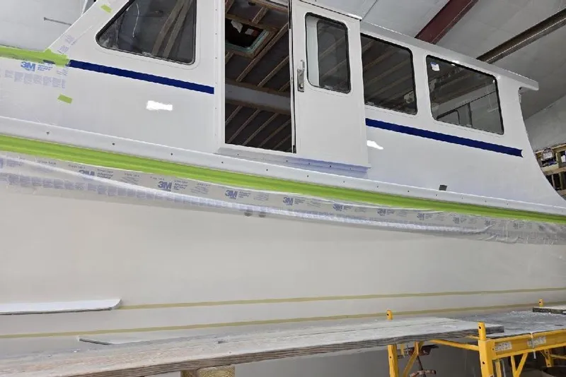 Slide: The Image of 2025 Calvin Beal Sedan boat under construction in a workshop. - 6