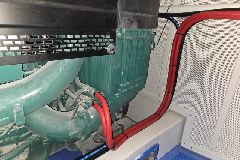 Slide: The Image of Engine compartment of a 2025 Calvin Beal Sedan with visible red and blue cables. - 65