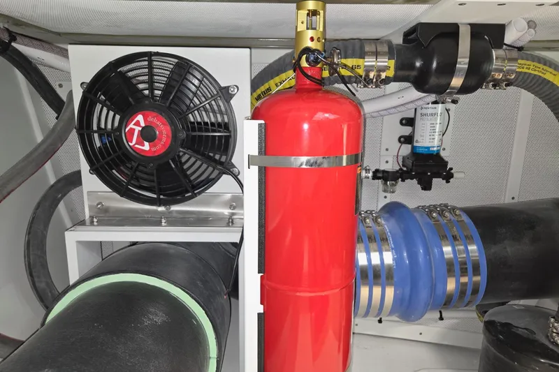 Slide: The Image of Engine compartment of 2025 Calvin Beal Sedan with fan, red cylinder, and hoses. - 74