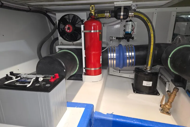 Slide: The Image of Engine compartment of a 2025 Calvin Beal Sedan with fire extinguisher and battery. - 75