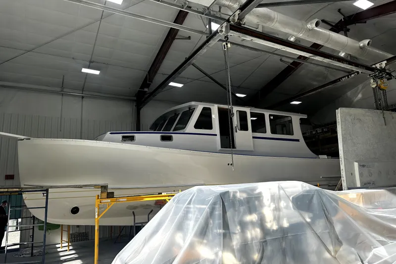 Slide: The Image of A 2025 Calvin Beal Sedan boat under construction in a workshop. - 8