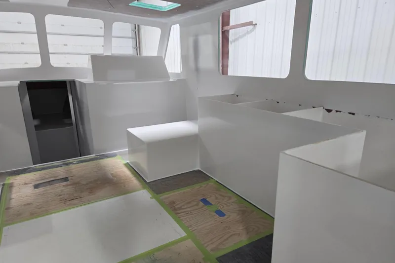 Slide: The Image of Interior of a 2025 Calvin Beal Sedan under construction, featuring unfinished white surfaces. - 80
