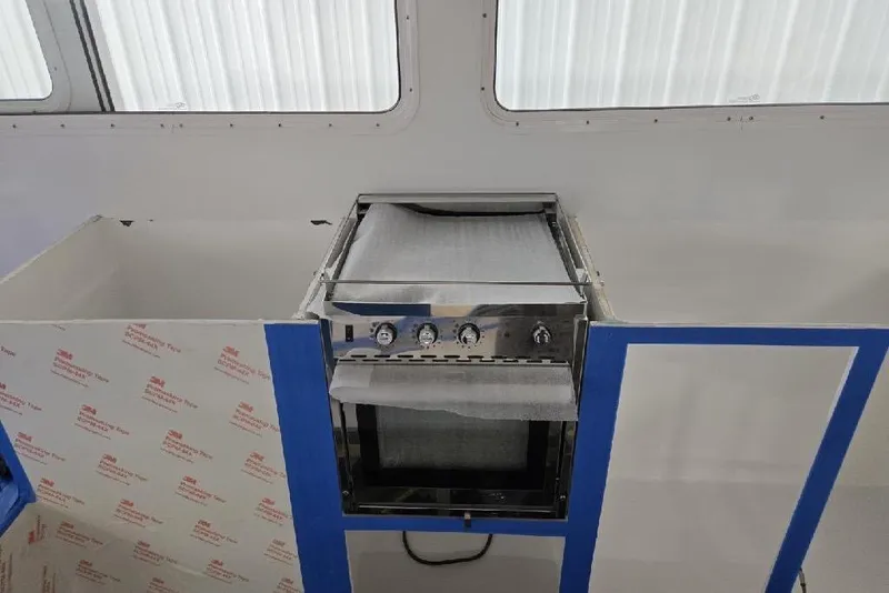 Slide: The Image of Modern kitchen setup inside 2025 Calvin Beal Sedan, featuring a sleek stainless steel oven. - 81