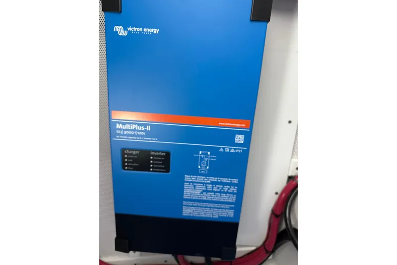 Slide: The Image of Victron Energy MultiPlus-II inverter charger, blue casing, installed with red cables. - 87