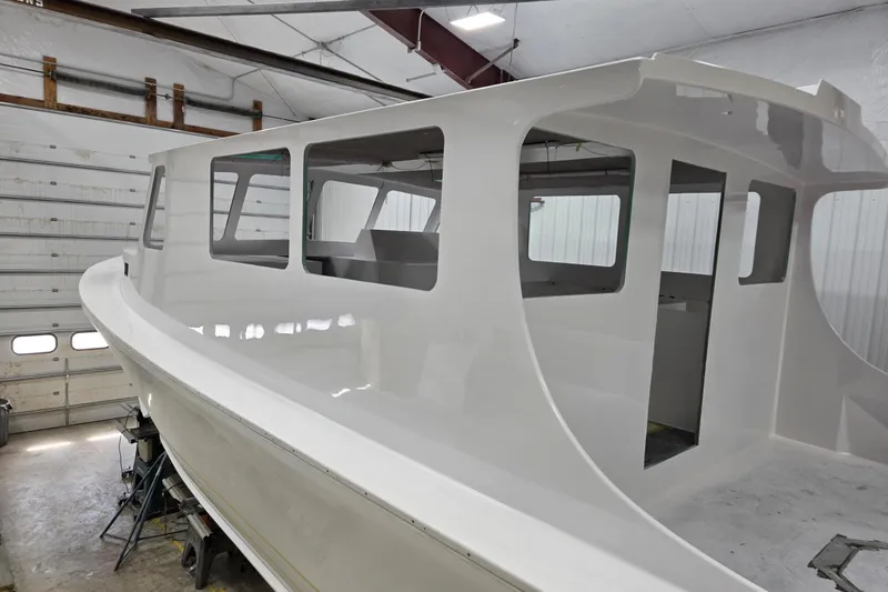 Slide: The Image of 2025 Calvin Beal Sedan boat under construction in a workshop. - 9