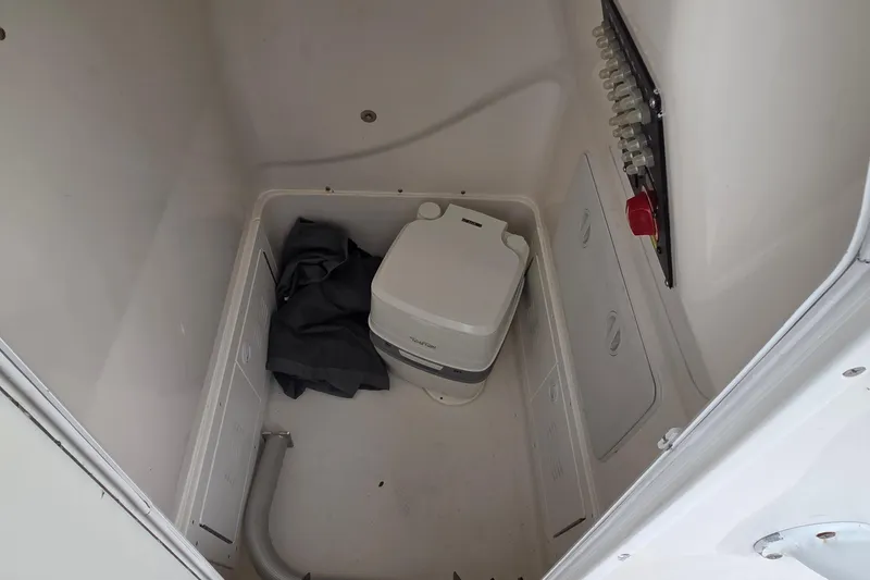 Slide: The Image of 2020 Blue Wave 2800 Makaira boat interior with portable toilet and storage area. - 15