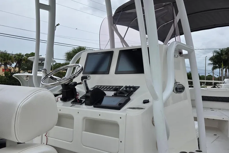 Slide: The Image of 2020 Blue Wave 2800 Makaira boat console with steering wheel and navigation screens. - 17