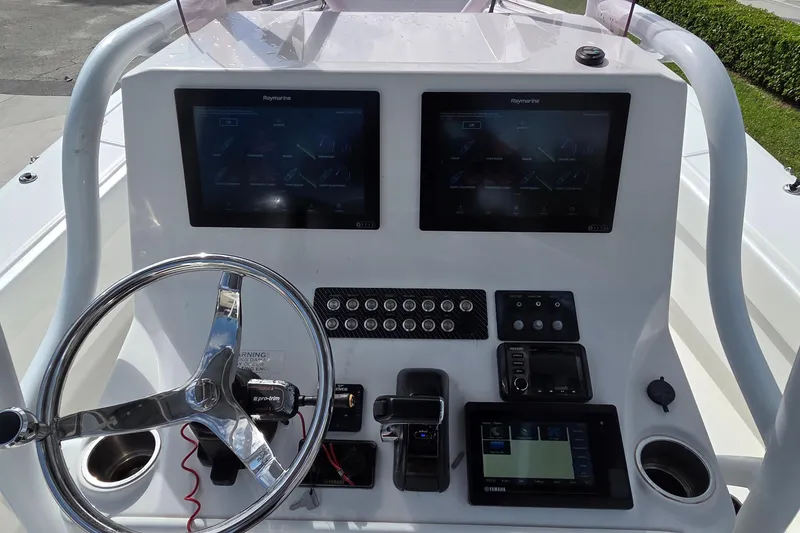 Slide: The Image of 2020 Blue Wave 2800 Makaira boat dashboard with dual Raymarine displays and steering wheel. - 4