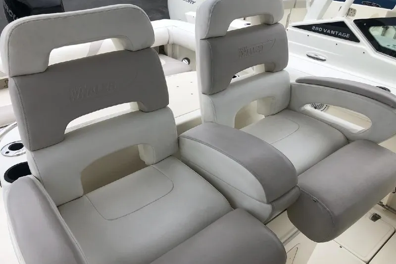 Slide: The Image of 2009 Boston Whaler 320 Outrage Cuddy Cabin boat seats, featuring plush gray and white upholstery. - 9