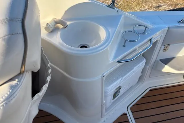 Slide: The Image of 2002 Regal Commodore 2765 boat interior with sink, cup holders, and wooden flooring. - 15