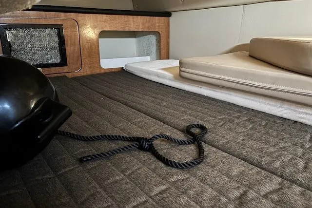 Slide: The Image of 2002 Regal Commodore 2765 cabin interior with cushions and rope on a quilted surface. - 25