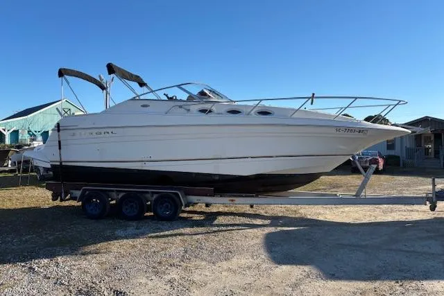 Slide: The Image of 2002 Regal Commodore 2765 boat on trailer, parked outdoors under clear blue sky. - 5