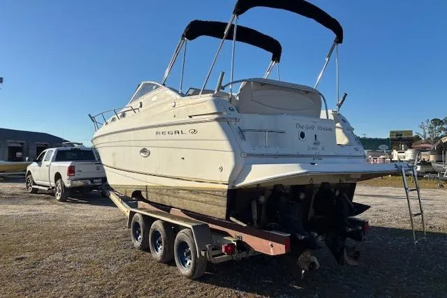 Slide: The Image of 2002 Regal Commodore 2765 boat on trailer, parked outdoors, with a pickup truck nearby. - 8