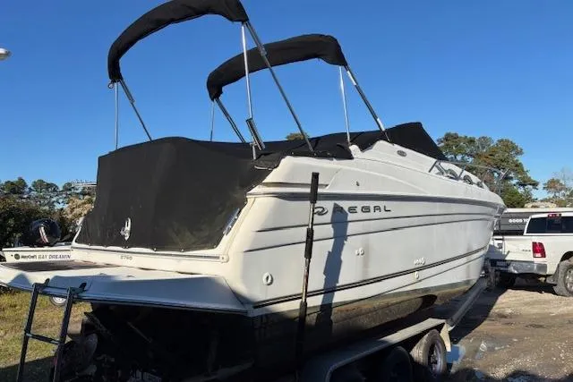 Slide: The Image of 2002 Regal Commodore 2765 boat with black canopy on a trailer, parked outdoors. - 9