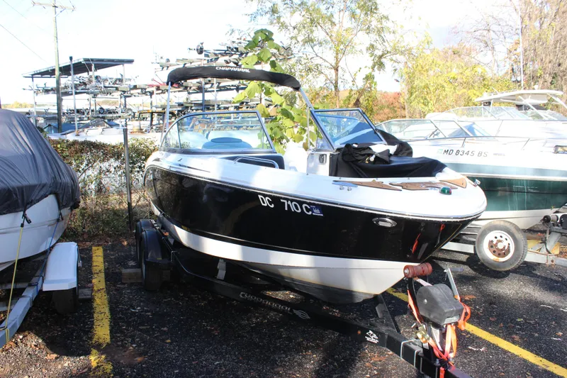 The Image of 2017 Chaparral 21 H2O Ski & Fish boat on trailer in parking lot. - 0
