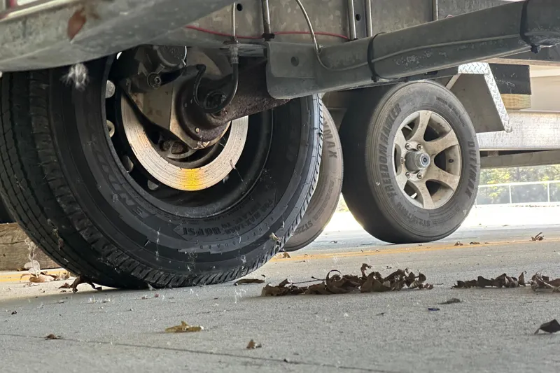 Slide: The Image of Trailer wheels on pavement, supporting a 1995 Grady-White Tournament 192 boat. - 13