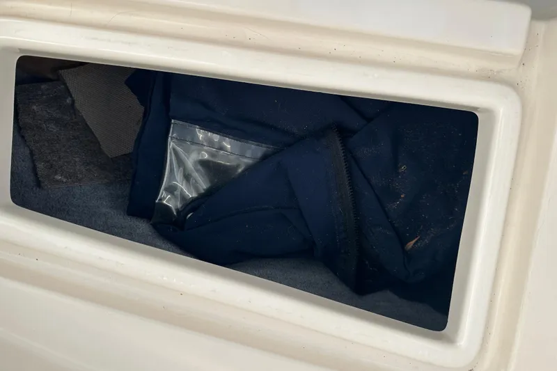 Slide: The Image of Storage compartment of 1995 Grady-White Tournament 192 boat with blue fabric and plastic bag. - 16