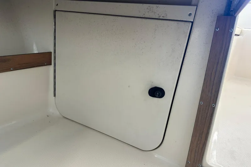 Slide: The Image of 1995 Grady-White Tournament 192 boat storage compartment with wooden trim. - 27