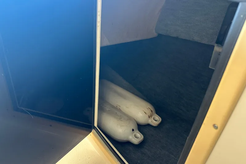 Slide: The Image of Storage compartment in 1995 Grady-White Tournament 192 boat with white fenders inside. - 31