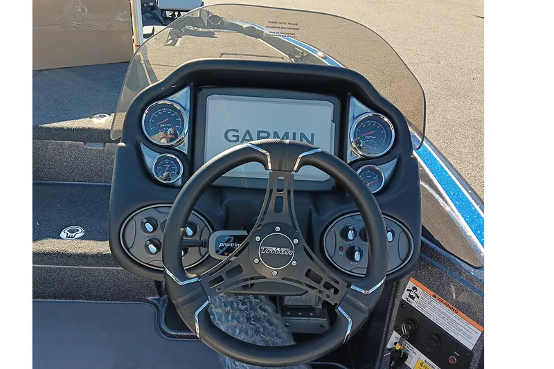 Slide: The Image of 2026 Triton 18 TrX boat dashboard with Garmin display and steering wheel. - 13