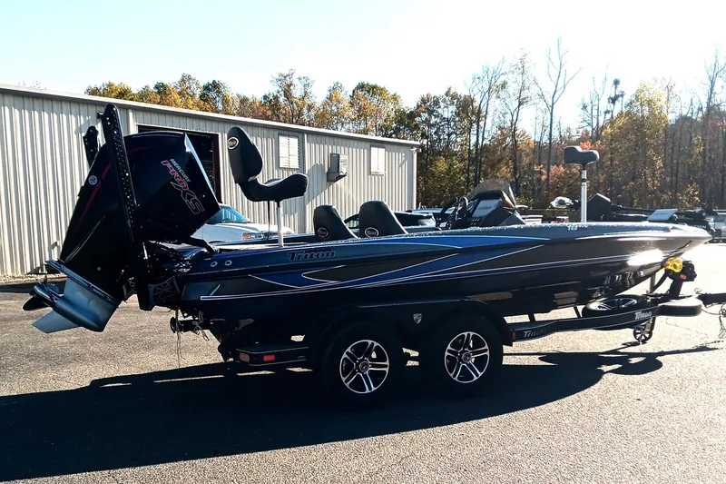 Slide: The Image of 2026 Triton 18 TrX boat on trailer, surrounded by autumn trees. - 2