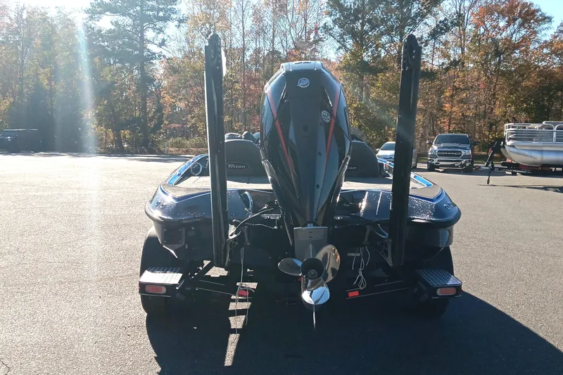 Slide: The Image of 2026 Triton 18 TrX bass boat with powerful outboard motor on a trailer. - 4