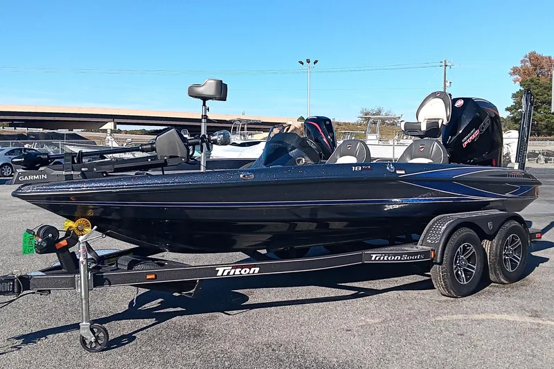 Slide: The Image of 2026 Triton 18 TrX boat on trailer, parked on grass, featuring Garmin equipment. - 5