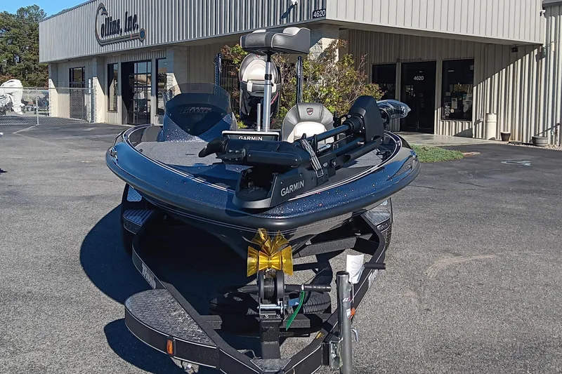 Slide: The Image of 2026 Triton 18 TrX boat on trailer, featuring Garmin equipment, parked on grass. - 6