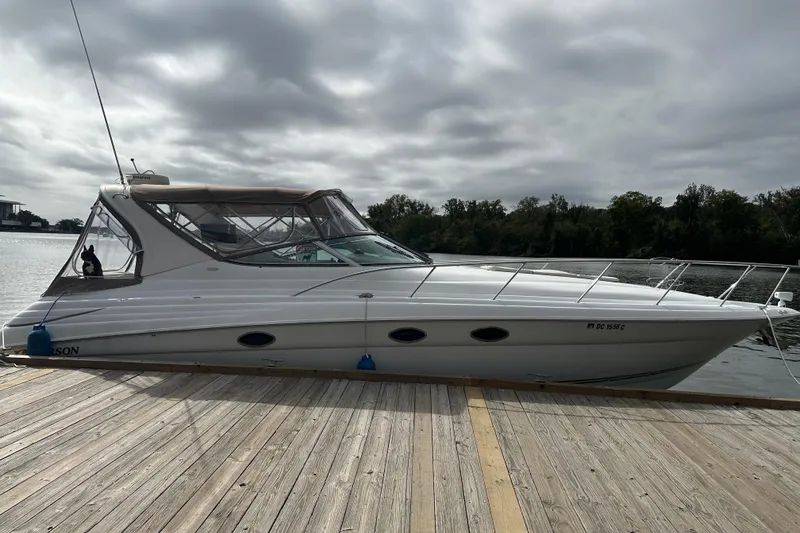 Slide: The Image of 2004 Larson 370 boat docked on a wooden pier under cloudy skies. - 0